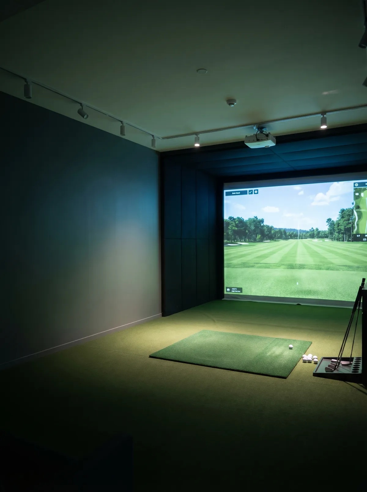Single golf simulator bay with hitting mat, projector, and impact screen