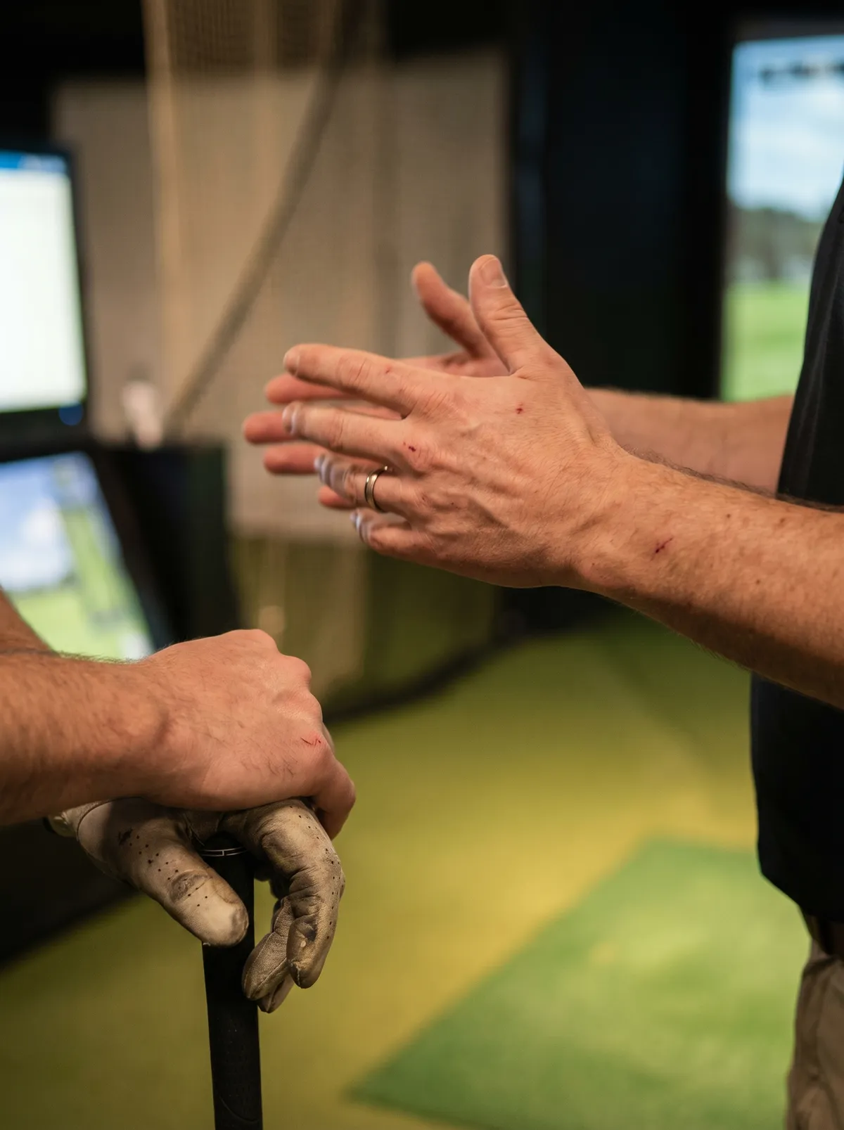 Golfer receiving coaching tips at an indoor golf simulator venue