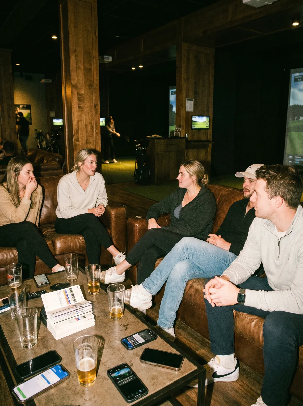 Customers socializing between simulator sessions at an indoor golf venue
